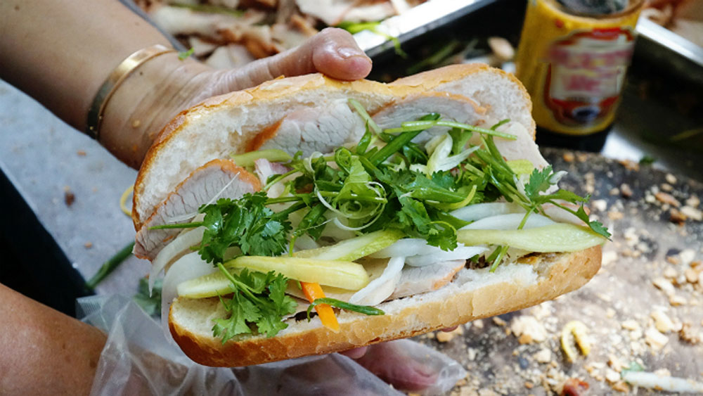 Nearly 90, Saigon street cart selling banh mi pate is an institution